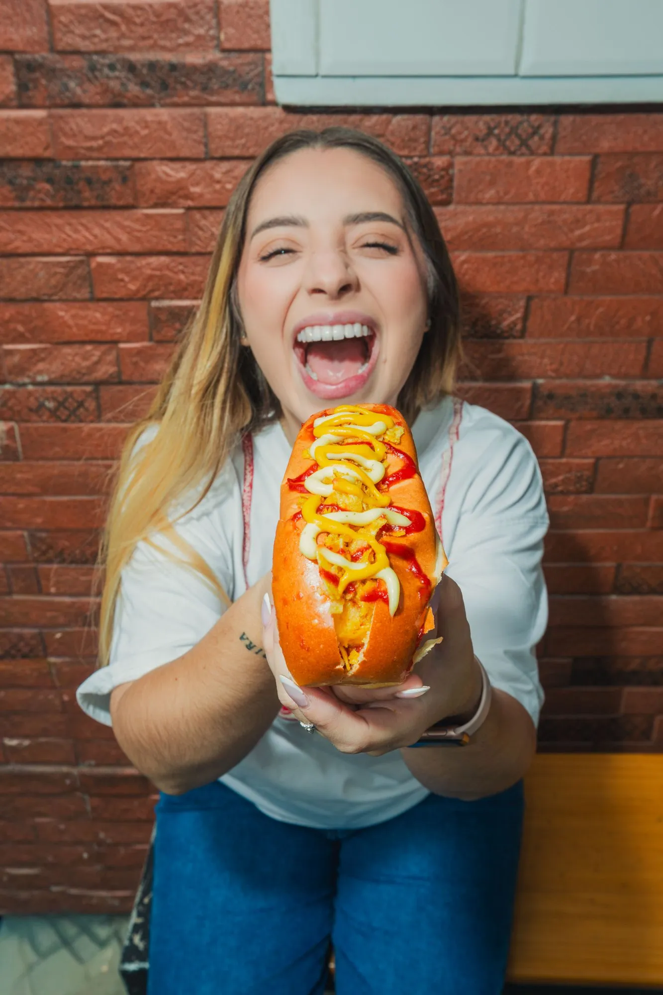 Cliente de La Caliente ofreciendo un hot dog